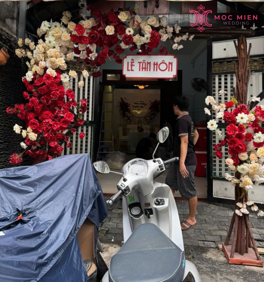 Cổng cưới tone đỏ - vàng kem được đặt ngay lối vào