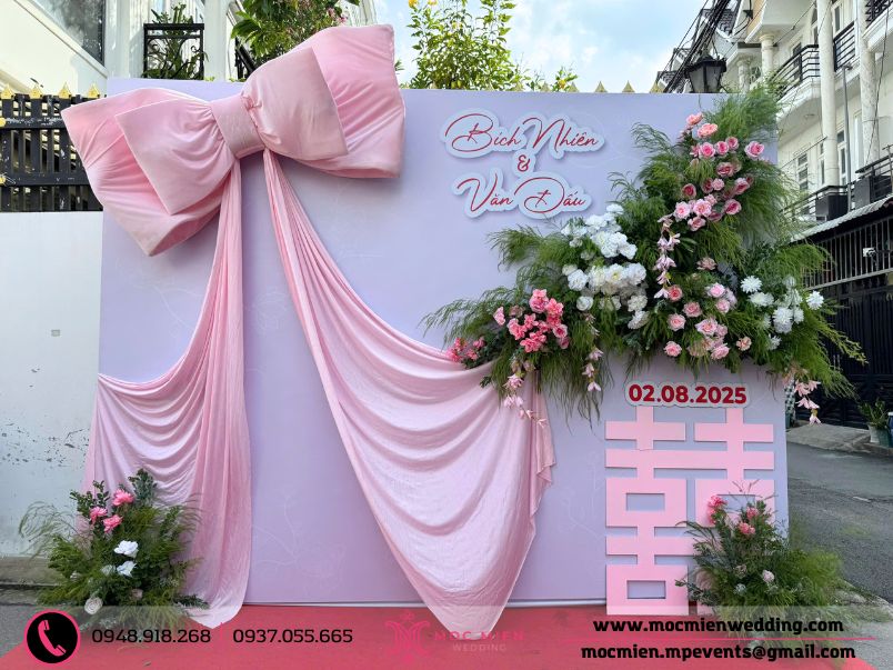 Trang trí backdrop nơ khổng lồ với hoa lụa lá tươi